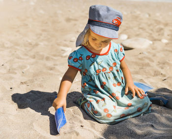 Full length of boy sitting on sand at beach