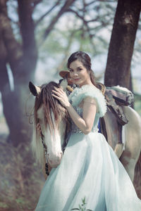 At sunset, a beautiful sensual girl and her horse go through the woods. horses are adored by girls.