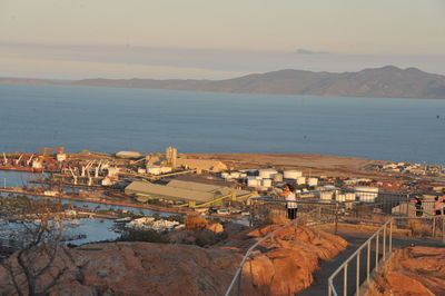 High angle view of townscape by sea against sky