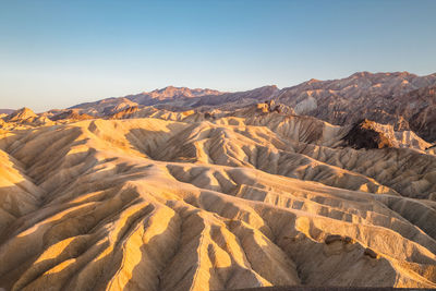 Scenic view of sand and rock formations against sky