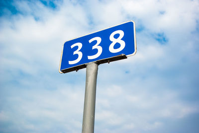 Low angle view of road sign against sky