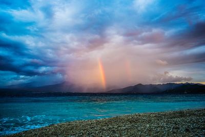 Scenic view of rainbow over sea against sky