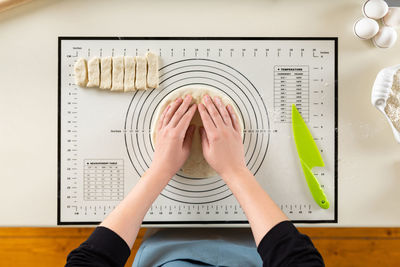 Cropped hand of woman making dough