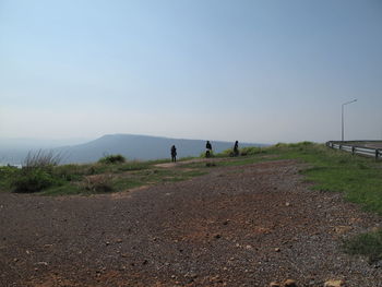 People walking on road against sky