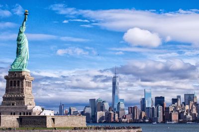 Skyscrapers in city against cloudy sky