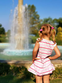 Rear view of girl looking at fountain in park