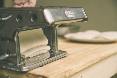 Cropped hand of person on dough machine