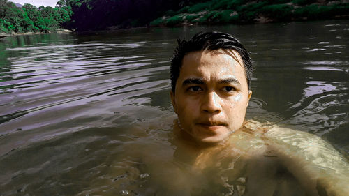 Portrait of young man swimming in lake