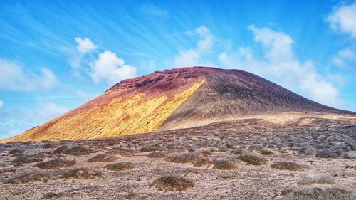 View of volcanic landscape against cloudy sky