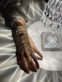 Close up of hand, softly lit by a lamp, one hand with a bracelet