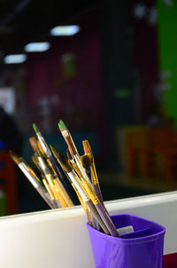 Close-up of paintbrushes reflecting on mirror