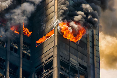 Fire on building against sky in city