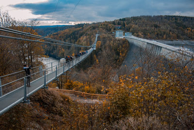 Road by bridge against sky during autumn