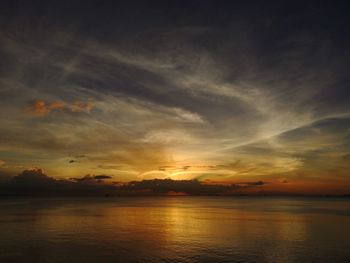 Scenic view of sea against dramatic sky during sunset