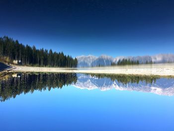 Scenic view of lake against clear blue sky