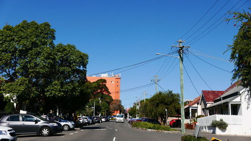 Cars on road against clear blue sky