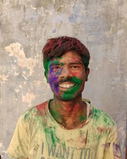 Portrait of smiling young man against wall