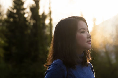 Woman looking away while standing outdoors