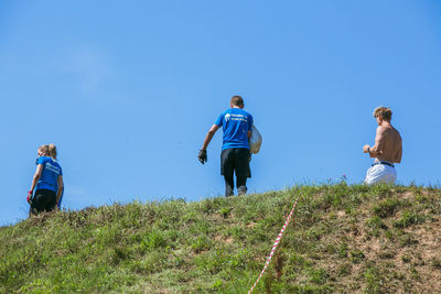 Rear view of man and daughter against clear sky