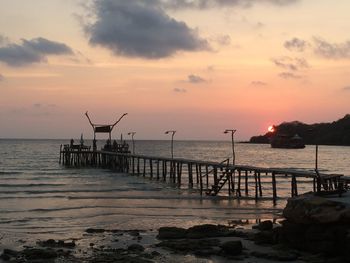 Pier on sea at sunset