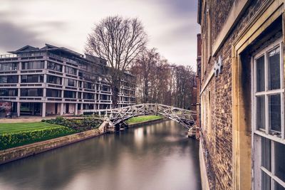 Canal amidst buildings against sky