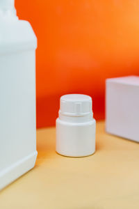 Close-up of pills in bottles on yellow background