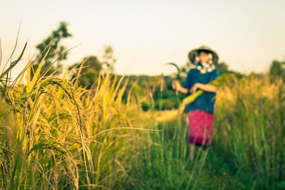 Woman standing on field against clear sky