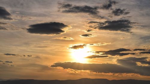 Sun shining through clouds during sunset