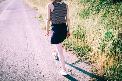 Rear view of woman walking on road