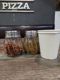 Close-up of coffee in jar on table, with pizza letter on background.. awaiting pizza