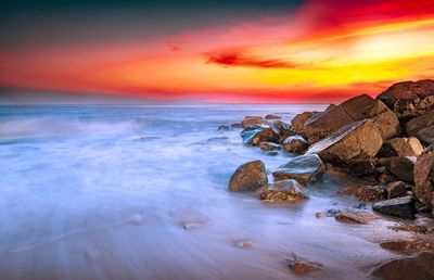 Scenic view of sea against romantic sky at sunset