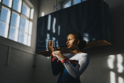 Contemplative teenage girl standing in school gymnasium