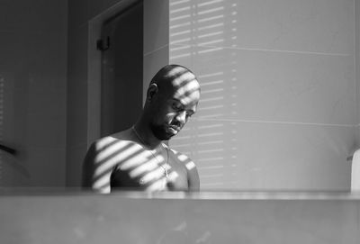 Reflection of shirtless man in mirror at home