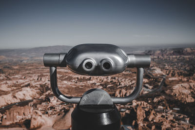 Close-up of coin-operated binoculars against cityscape