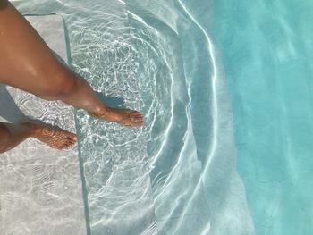 Low section of woman swimming in pool