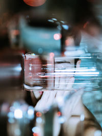 Young man sleeping on table seen through drinking glass at home