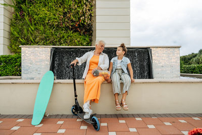 Portrait of happy senior women and granddaughter resting on the bench