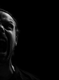 Portrait of mid adult man against black background