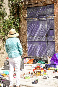 Rear view of man against built structure