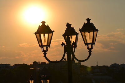 Low angle view of illuminated street light against sky during sunset