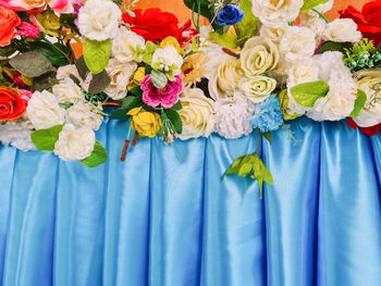 Close-up of rose bouquet against blue wall