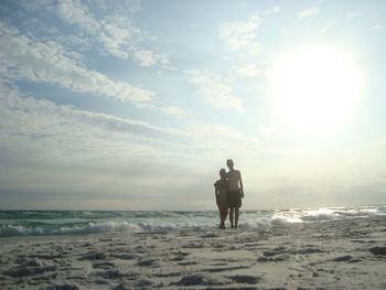 Men on beach against sky