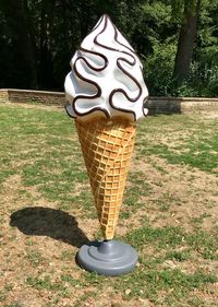 Close-up of ice cream cone on field in park