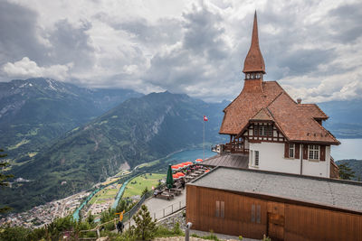 Traditional building by mountains against sky