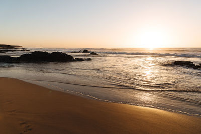 Scenic view of sea against clear sky during sunset