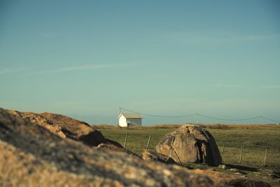 Small isolated house in a landscape with grass and rocks