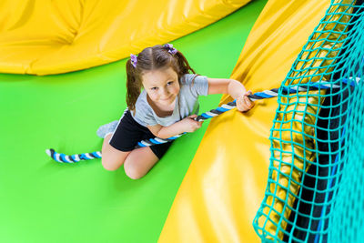 Full length of smiling girl playing on playground