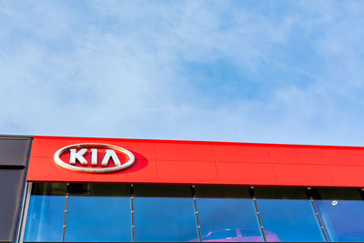 Low angle view of red sign against sky