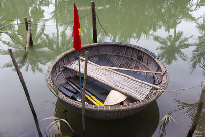 Boat moored on lake against trees