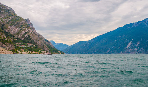 Scenic view of sea by mountains against sky